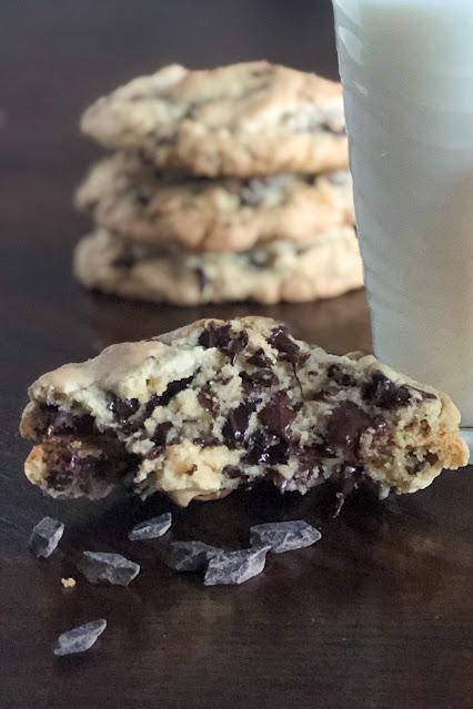 large chocolate chip cookie from the inside with a glass of milk