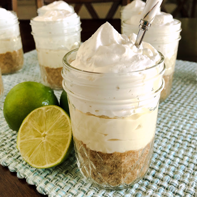 layers of graham cracker, cheesecake filling and whipped cream in a jar