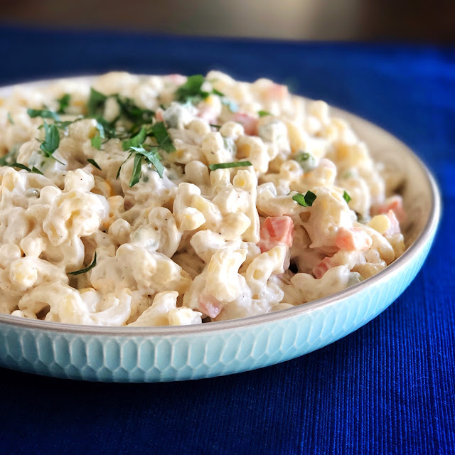 macaroni salad in a white plate on a blue mat