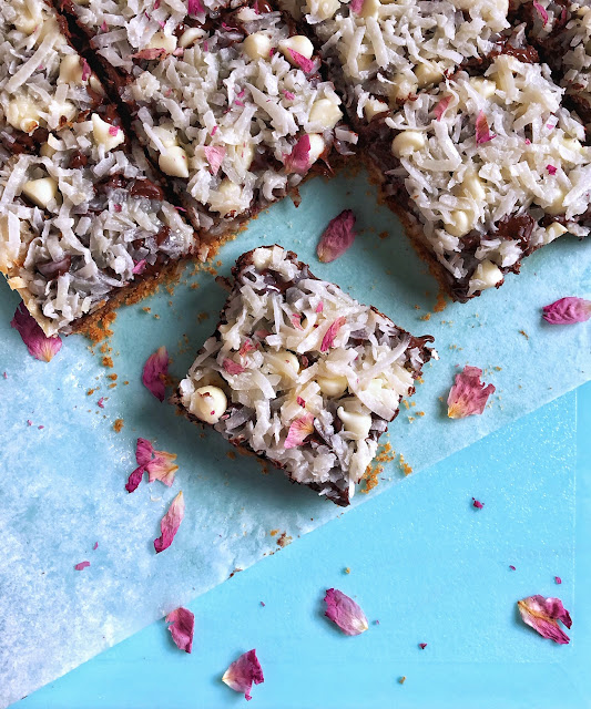 cookie bars with coconut and rose petals on a blue tray