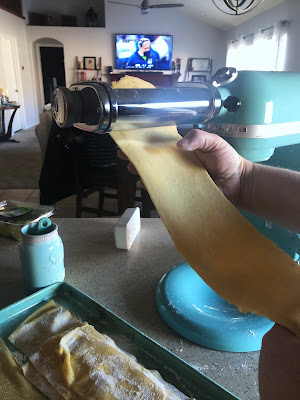 pasta dough going through a pasta roller