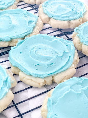sugar cookies with a swirl of aqua frosting on top