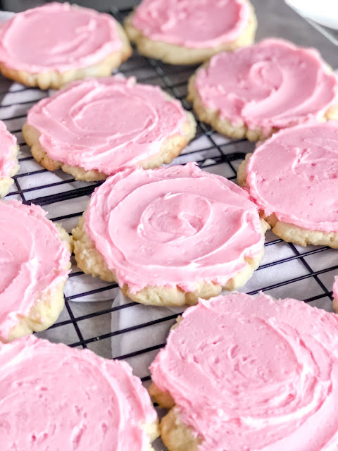 sugar cookies with pink almond frosting on top