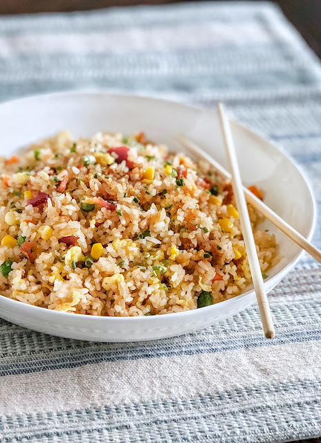 fried rice with bacon and egg in a white dish