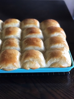 buttered baked rolls on an aqua baking tray
