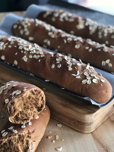 baked loaves of brown bread with oats