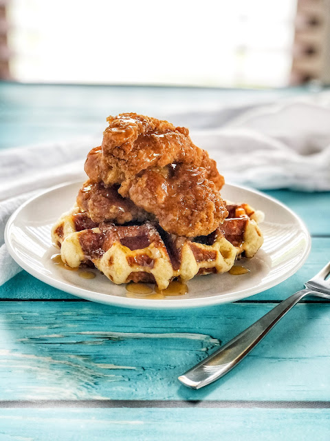 white plate with chicken and waffles and syrup