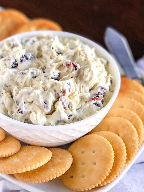 cream cheese spread in a white serving bowl with crackers