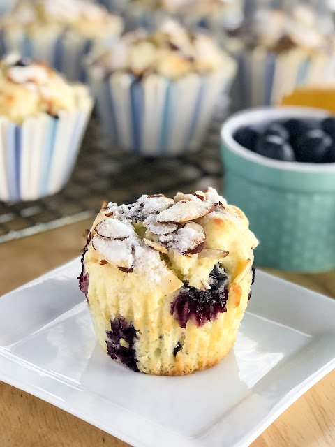 lemon blueberry muffin with sugared almonds on a white plate