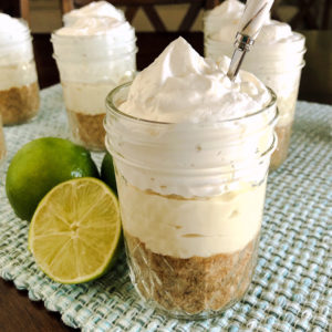 layers of graham cracker, cheesecake filling and whipped cream in a jar