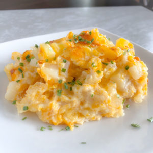 cheesy potatoes on a white plate