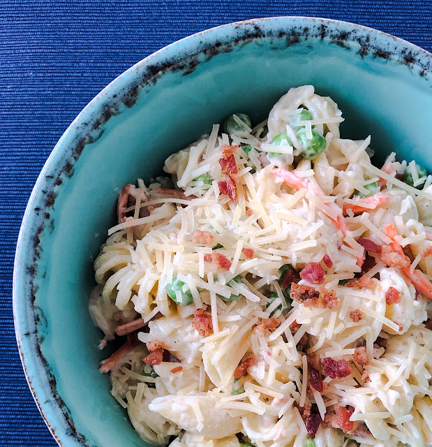 pasta salad in a blue bowl covered with cheese