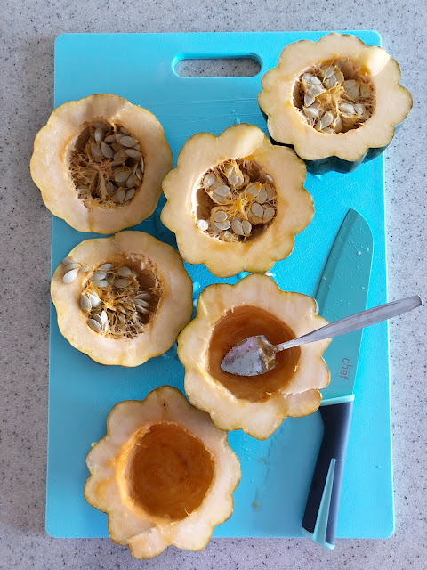 sliced acorn squash with seeds on a blue cutting board