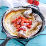 puff pancake with strawberries in a cast iron pan