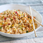 fried rice with bacon and egg in a white dish