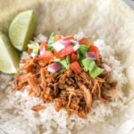sweet shredded pork with white rice and pico de gallo on a white tortilla with limes