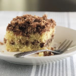 coffee cake with crumb topping on a white plate