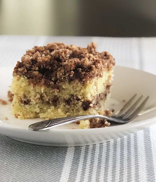 coffee cake with crumb topping on a white plate