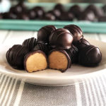 peanut butter balls stacked on a white plate