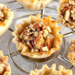 phyllo cups filled with pecans on a cooling rack