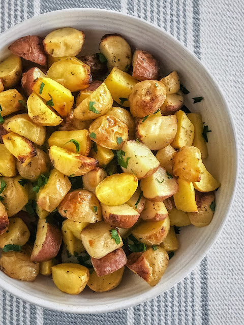 roasted potatoes with parsley in a white bowl