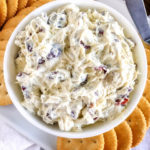 cream cheese spread in a white bowl with crackers