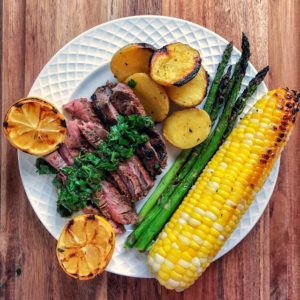 grilled steak with chimichurri, corn, lemons and asparagus