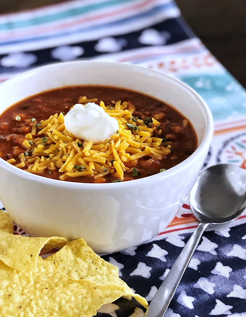 taco soup in a bowl with cheese and sour cream