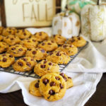 pumpkin chocolate chip cookies on a cooling rack in front of fall decor