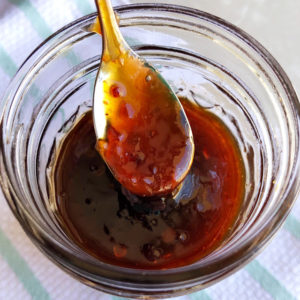 sauce on a spoon over a jar
