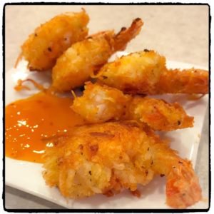 coconut shrimp with apricot sauce on a white plate