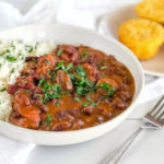 red beans with sausage and rice sprinkled with parsley and cornbread on the side