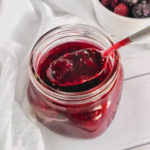 mixed berry sauce in a jar with a spoon