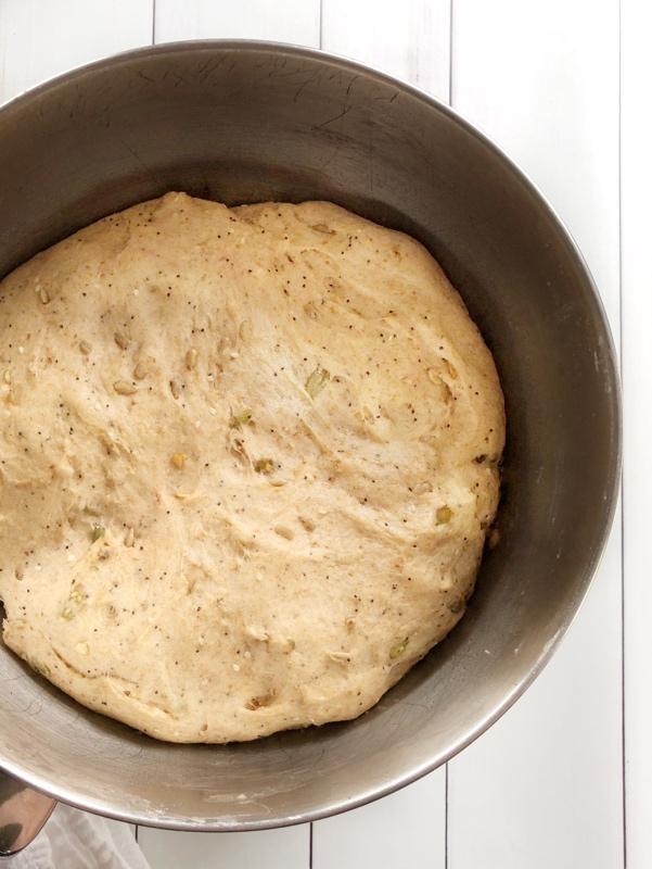 multi-seed honey wheat bread dough in a bowl