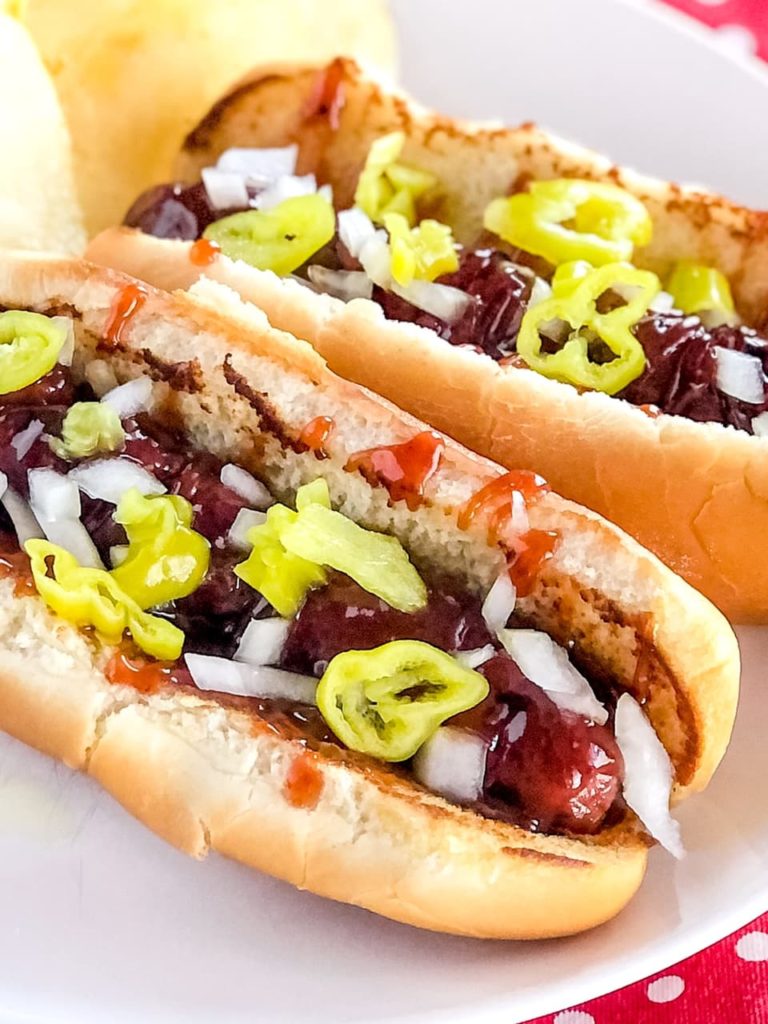 hot dogs on a bun with peppers and onions