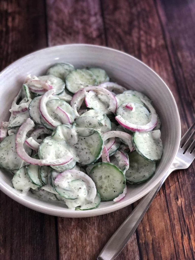 cucumbers and onions with dressing in a bowl