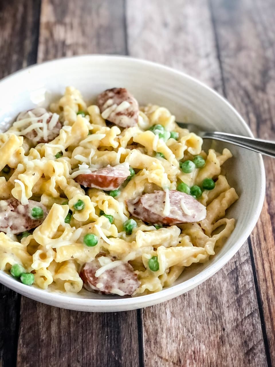 pasta with sausage and peas in a bowl