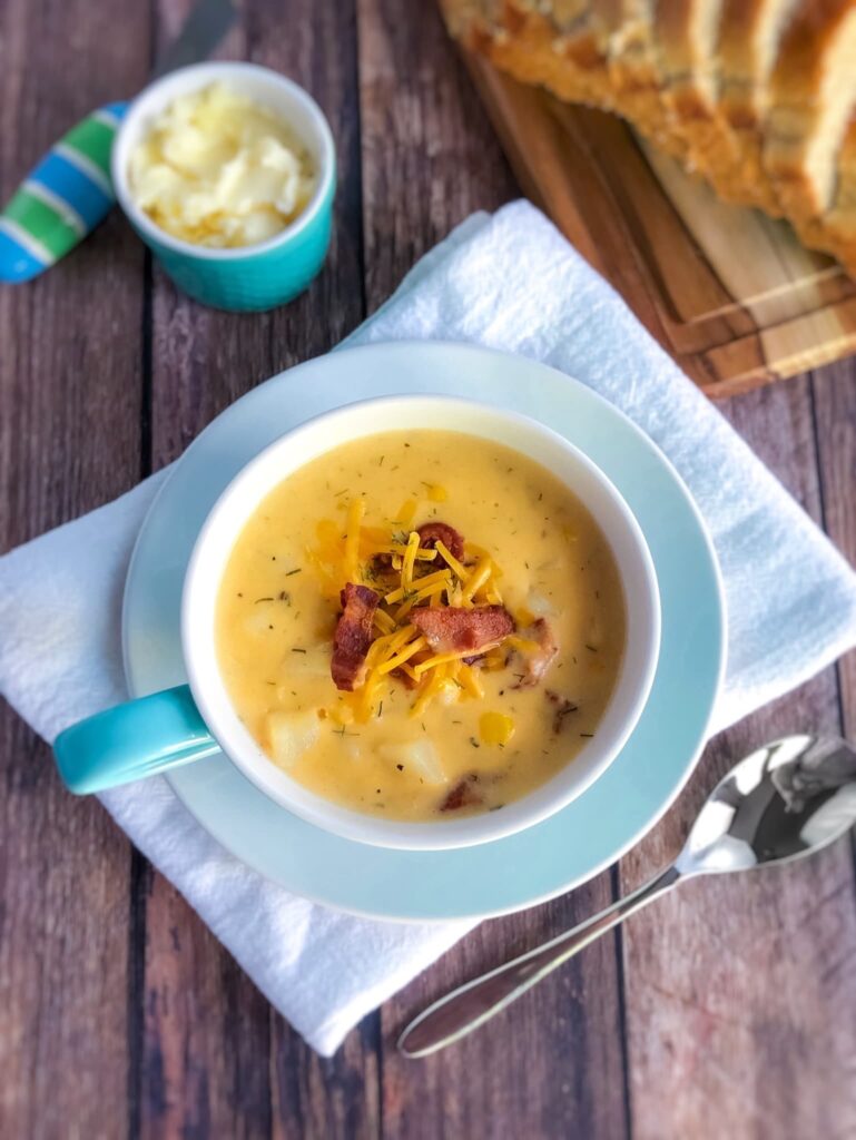 cheese soup in a mug with bread and butter on the side