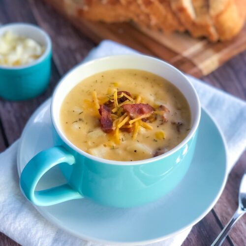 cheese soup in a mug with bread and butter on the side