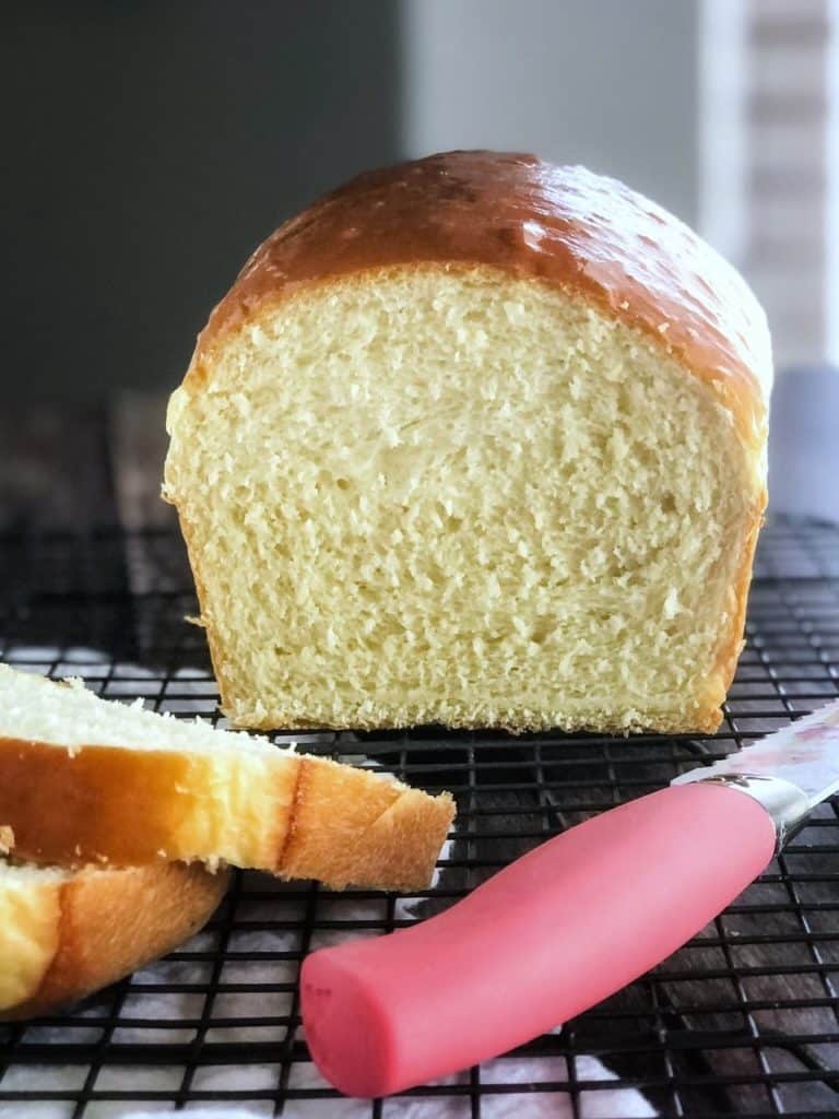 loaf of bread with slices and knife