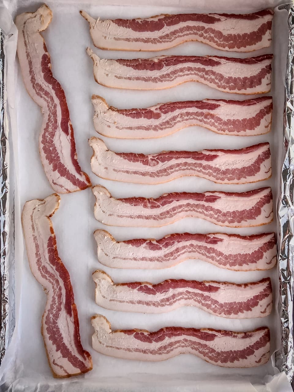 raw bacon on a baking tray