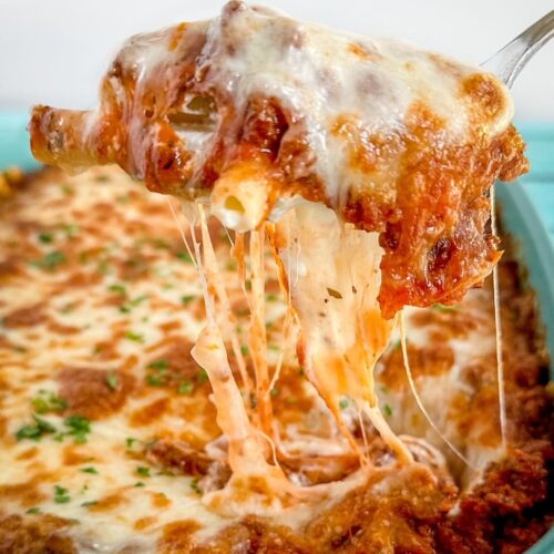 baked ziti casserole with a gooey spoon over the top