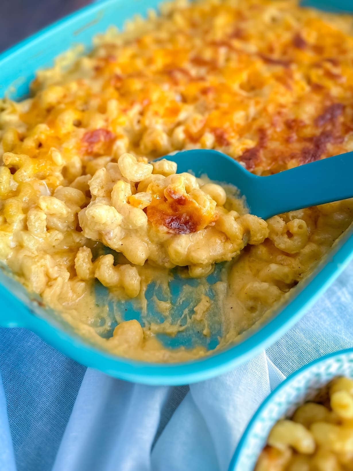 Close‑up of creamy baked mac & cheese with golden bubbly cheese on top