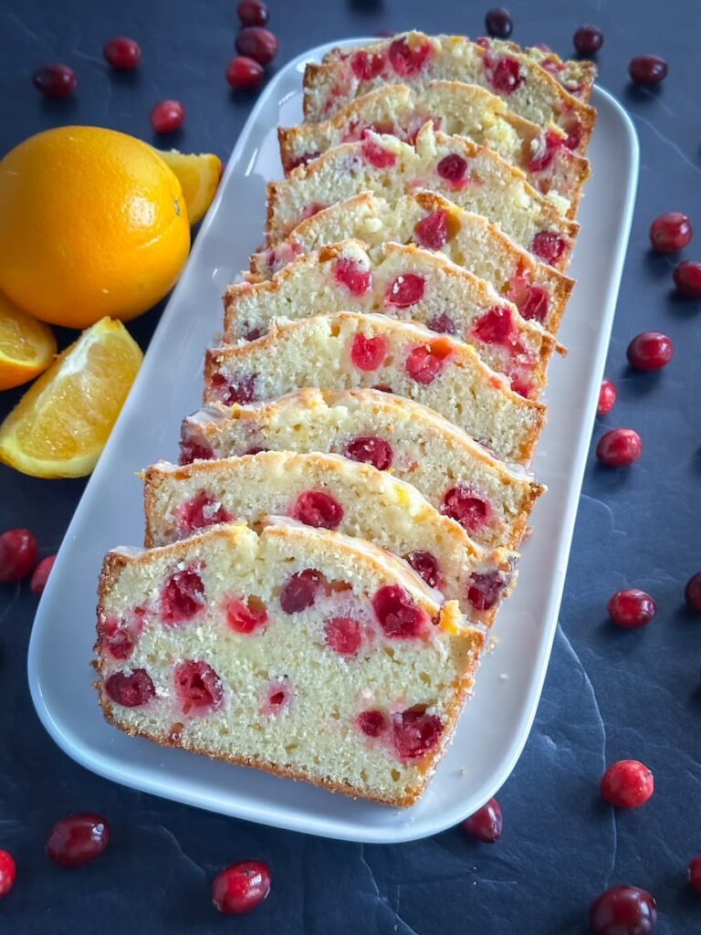 cranberry orange loaf sliced on a white platter