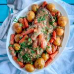 slow cooker pot roast with carrots potatoes and onions on a plate