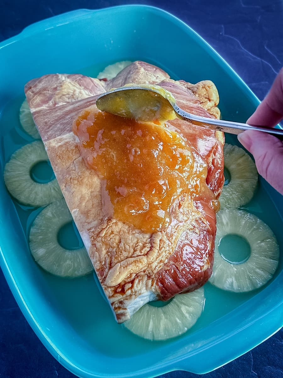 Boneless carver ham coated in peach‑Dijon glaze before baking