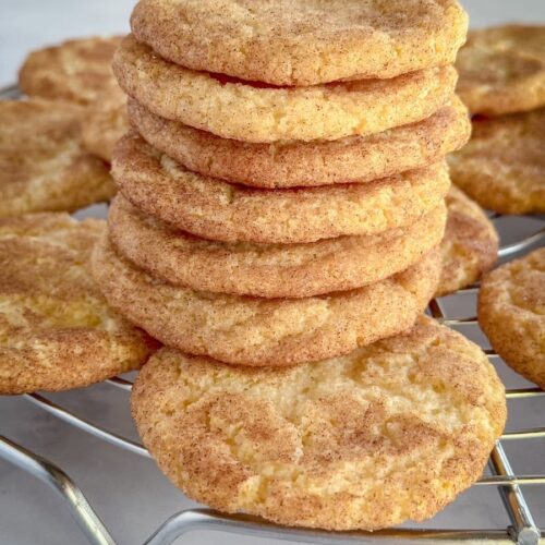 snickerdoodles stacked on a cooling rack