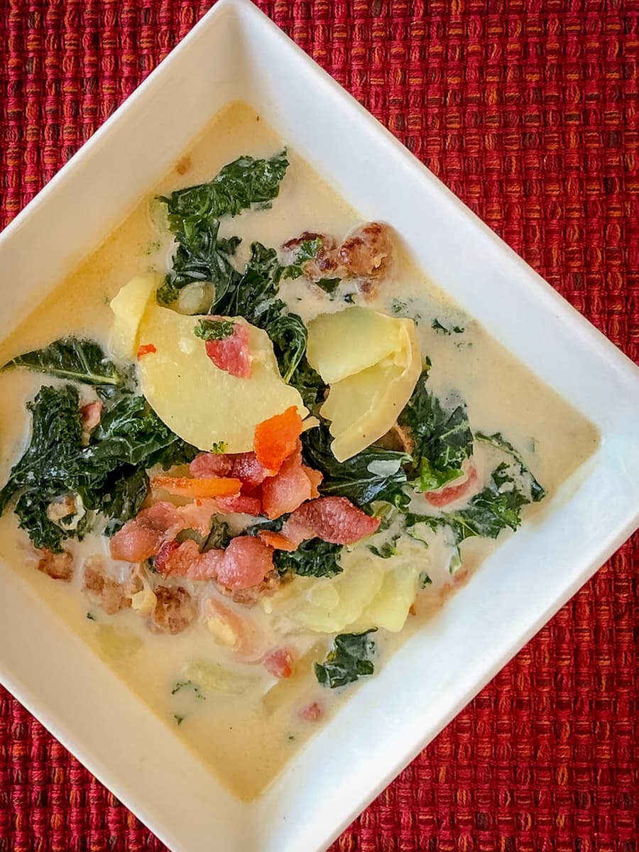 Bowl of creamy Zuppa Toscana soup with sausage, potatoes, and kale